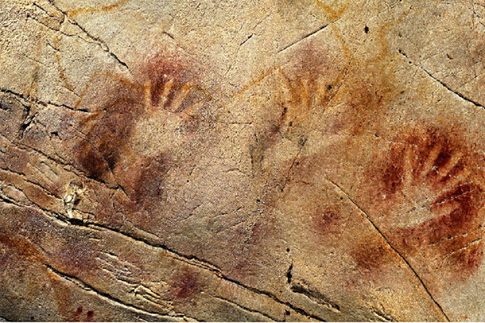 The 'Panel of Hands' in El Castillo Cave, Spain. With red disks and hand stencils made by blowing or spitting paint onto the wall. The painting appers to be far older than previusly thought; older than 40,800 years, making it the oldest known cave art in Europe. Credit: Pedro Saura/AAAS/AP